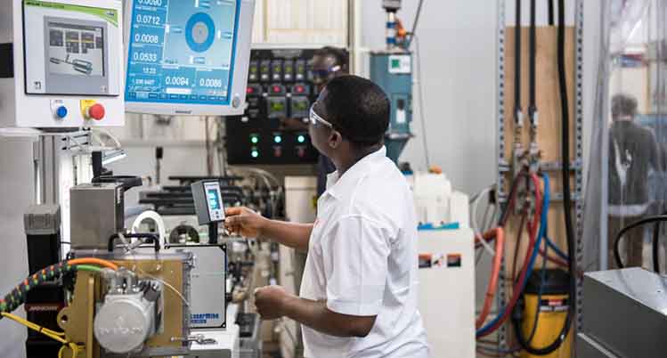 Plastic student working on machine