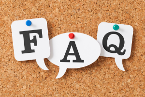 Speech bubble icons spelling 'FAQ' pinned to a corkboard, representing frequently asked questions about accreditation.