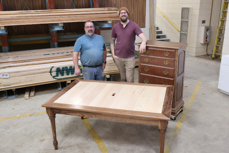 Tom Fritz and Doug Krauss pose next to Tom's custom built table and dresser.